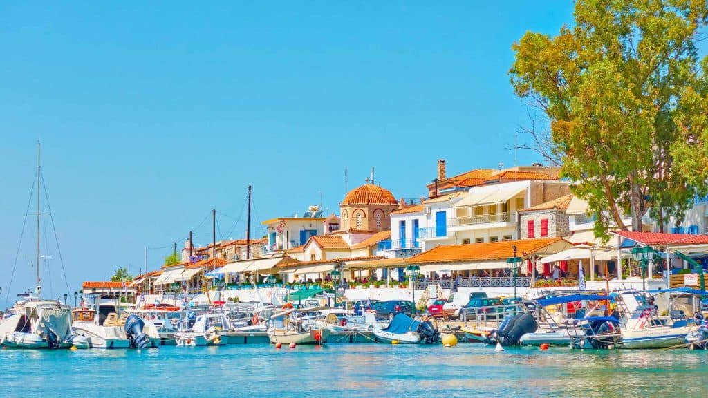 Λιμανάκι στην Πέρδικα της Αίγινας με πολύχρωμα σπιτάκια, ψαροκάικα και γραφικές ταβέρνες δίπλα στη θάλασσα.