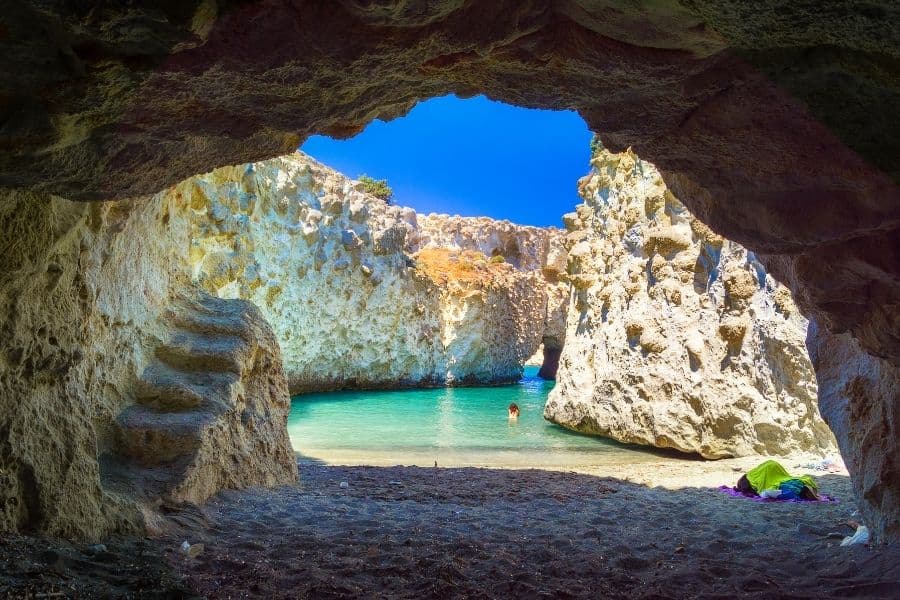 View of a beach on the island of Milos from inside a naturally formed cave.