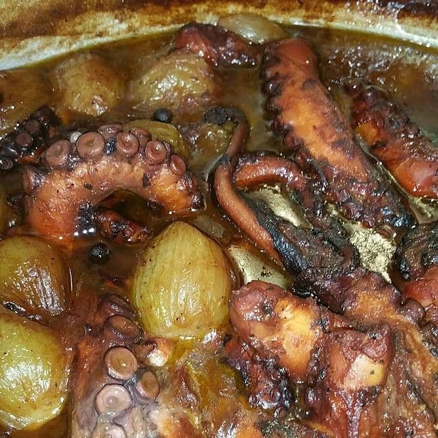 Du calamar frit avec des oignons cuits dans une marmite.