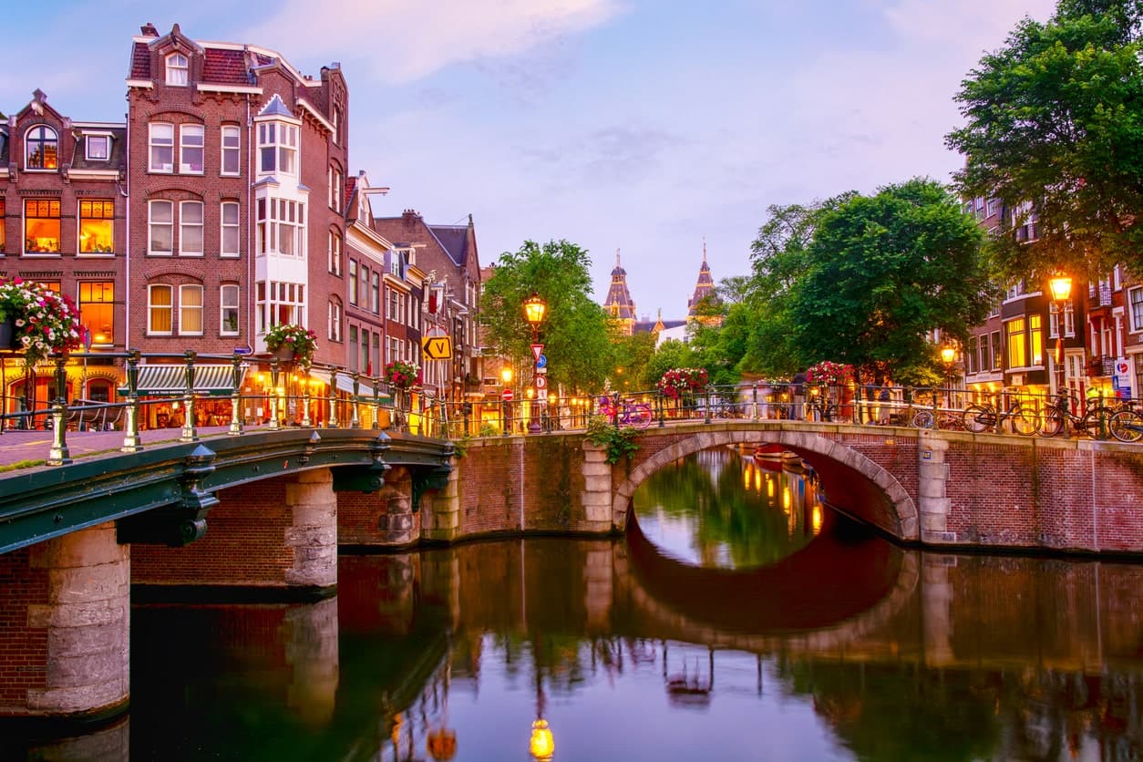 Streetlights glow atop one of Amsterdam's many canals.