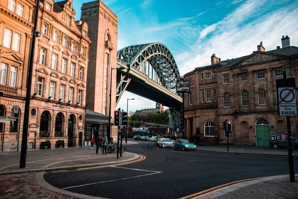 Newcastle mit der Tyne Bridge, historischen Gebäuden und belebten Straßen bei Tageslicht.