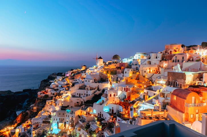 La ville emblématique de Santorini illuminée de mille feux après le coucher du soleil.