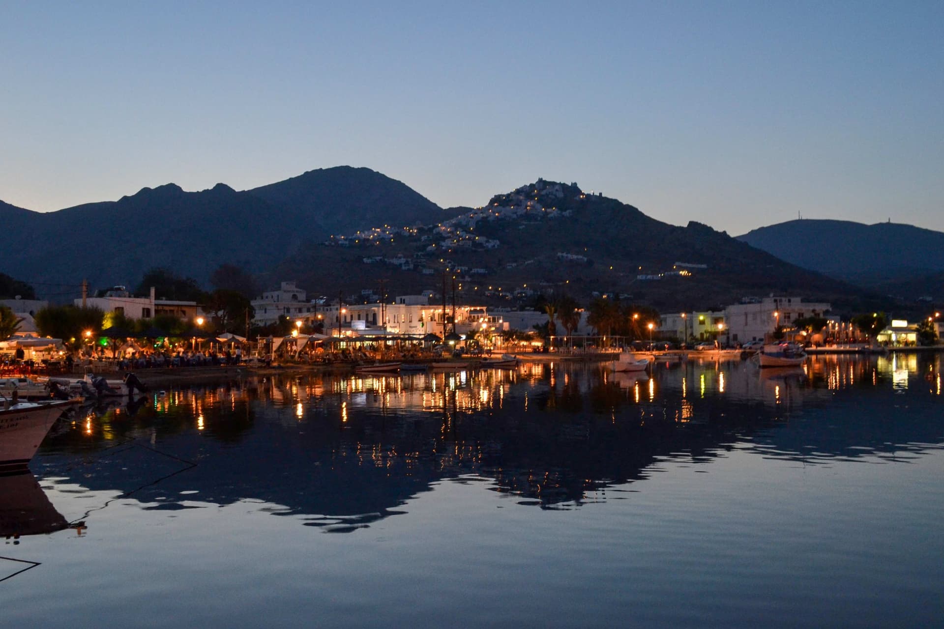 Evening lights twinkle across the shore of Serifos, Greece.