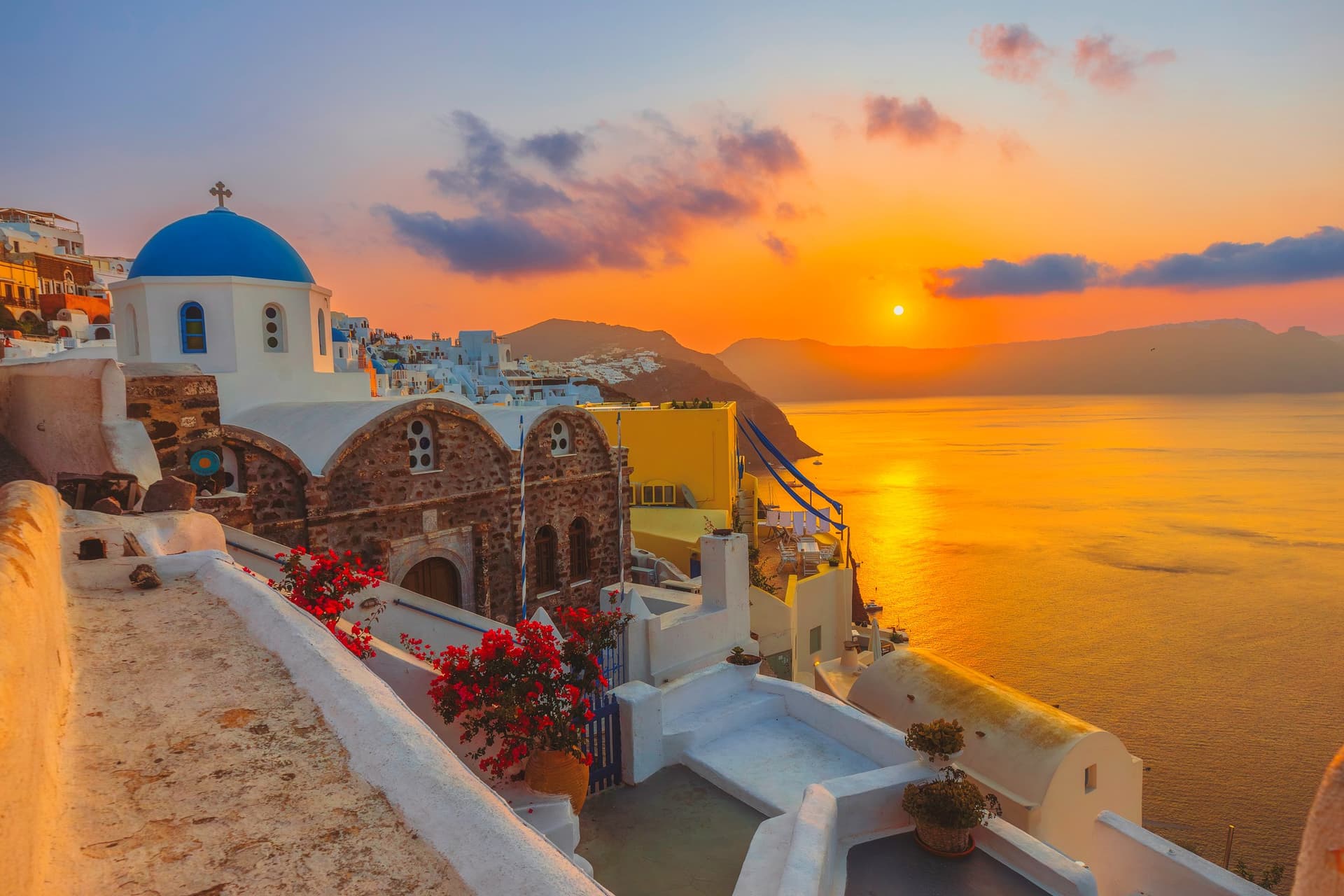 The sun sets over the hills of Santorini, Greece.