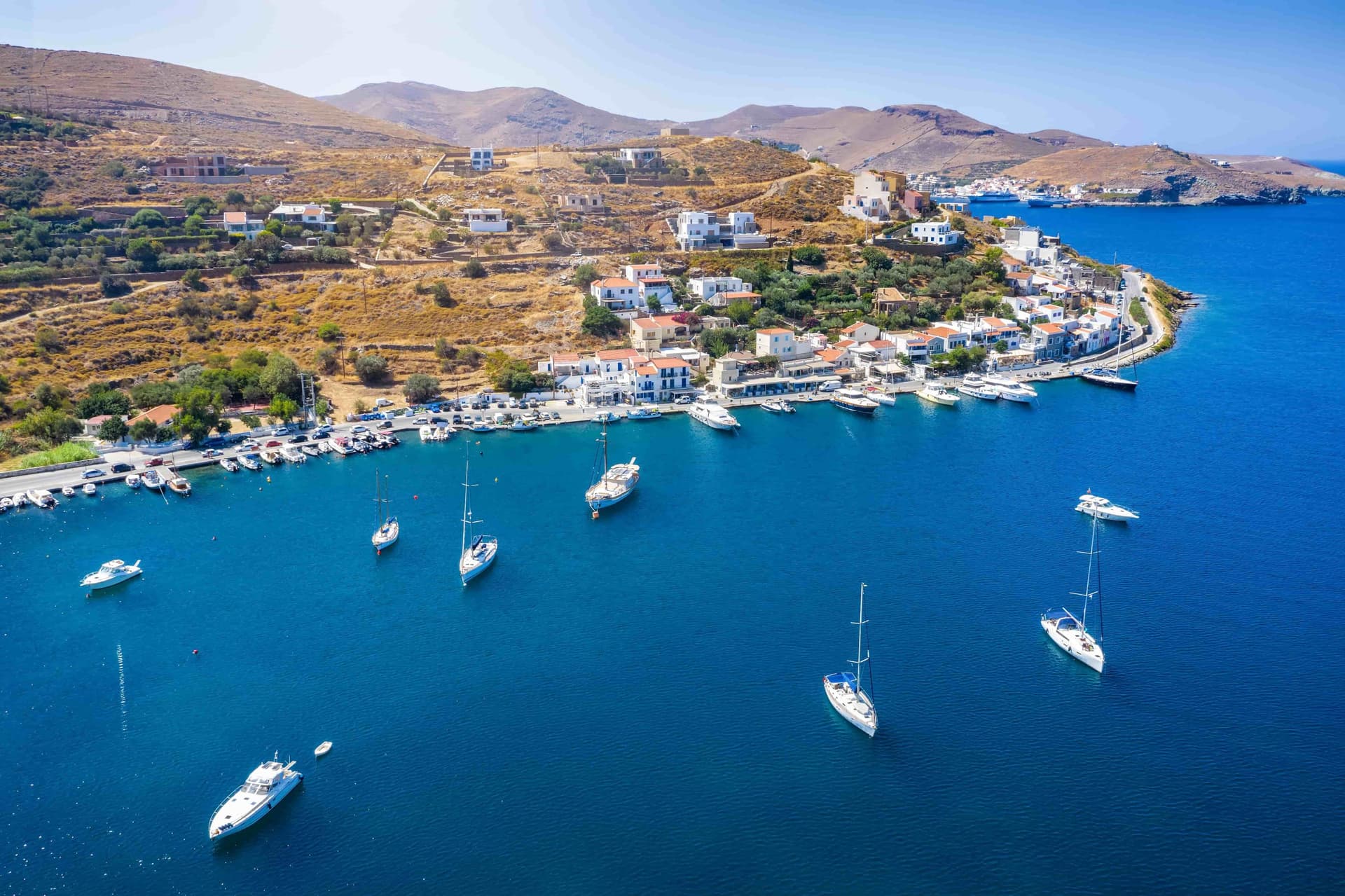 The harbour of Kea, Greece, dotted by white sailboats.