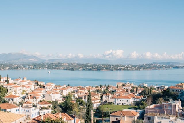 Veduta panoramica dell’isola di Spetses, con le tipiche case bianche dai tetti rossi affacciate sul mare calmo e azzurro