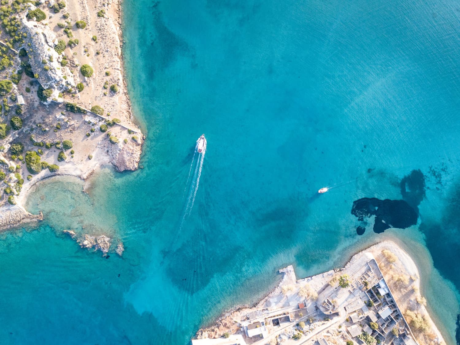 un petit port dans les rochers avec un bateau sur une eau turquoise
