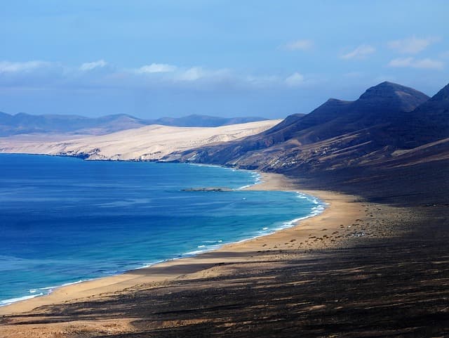 Spiaggia sabbiosa lunga e deserta che si estende lungo la costa