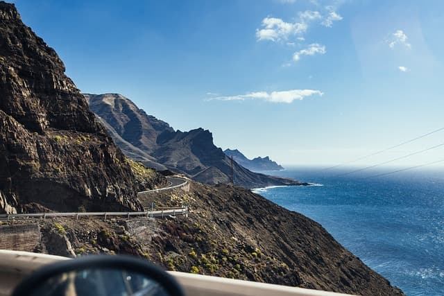 Strada panoramica che si snoda lungo una scogliera rocciosa a picco sul mare