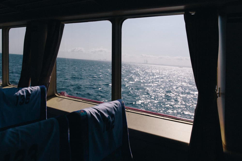 Interior of a ferry with a view of the sea through large windows