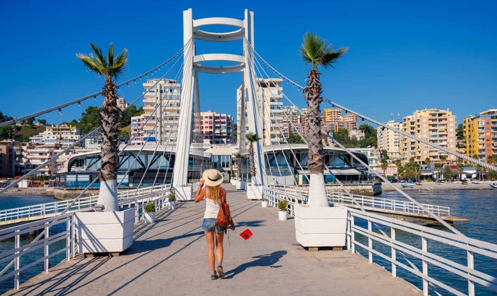 Djevojka hoda prelazi most u gradu Draču u Albaniji i nosi albansku zastavicu.