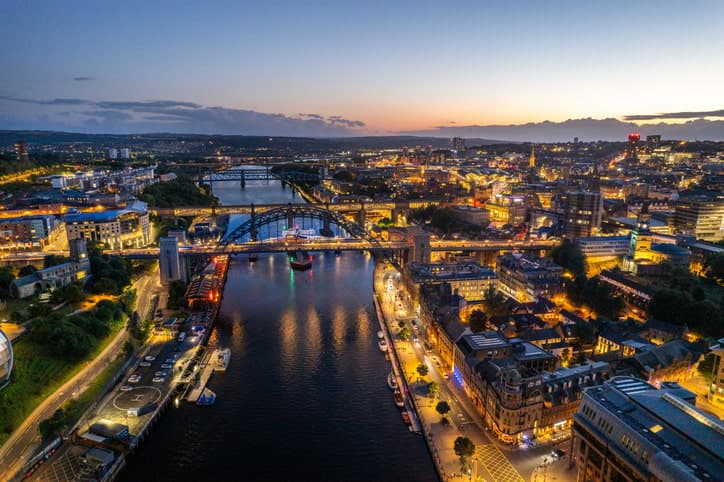 Newcastle upon Tyne, United Kingdom, at dusk, with city lights reflecting beautifully on the River Tyne