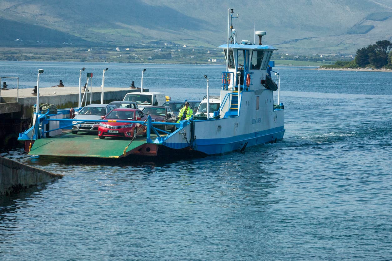 A ferry with cars docking on an Irish quay.