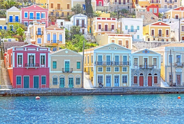 Pittoresco porto di Symi, celebre per le sue case neoclassiche color pastello che si affacciano direttamente sull’acqua