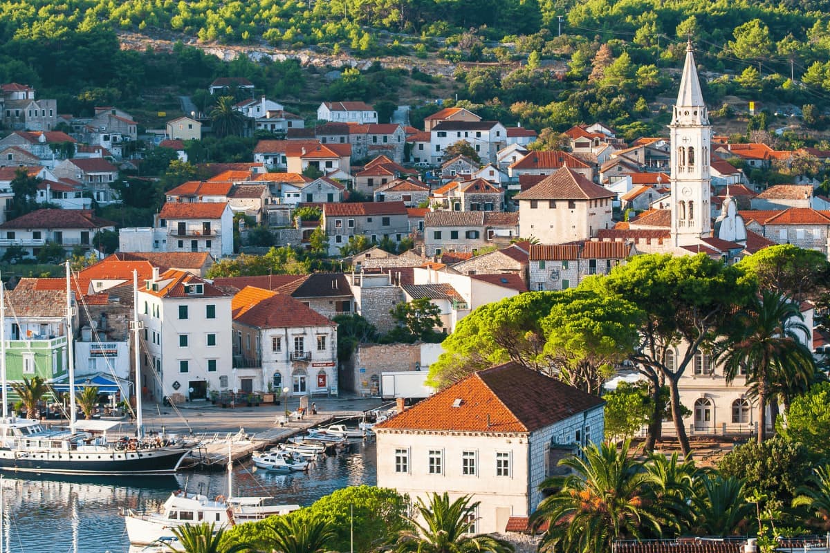Pogled na crkvu i ostale kuće od bijelog kamena u luci u Jelsi na otoku Hvaru