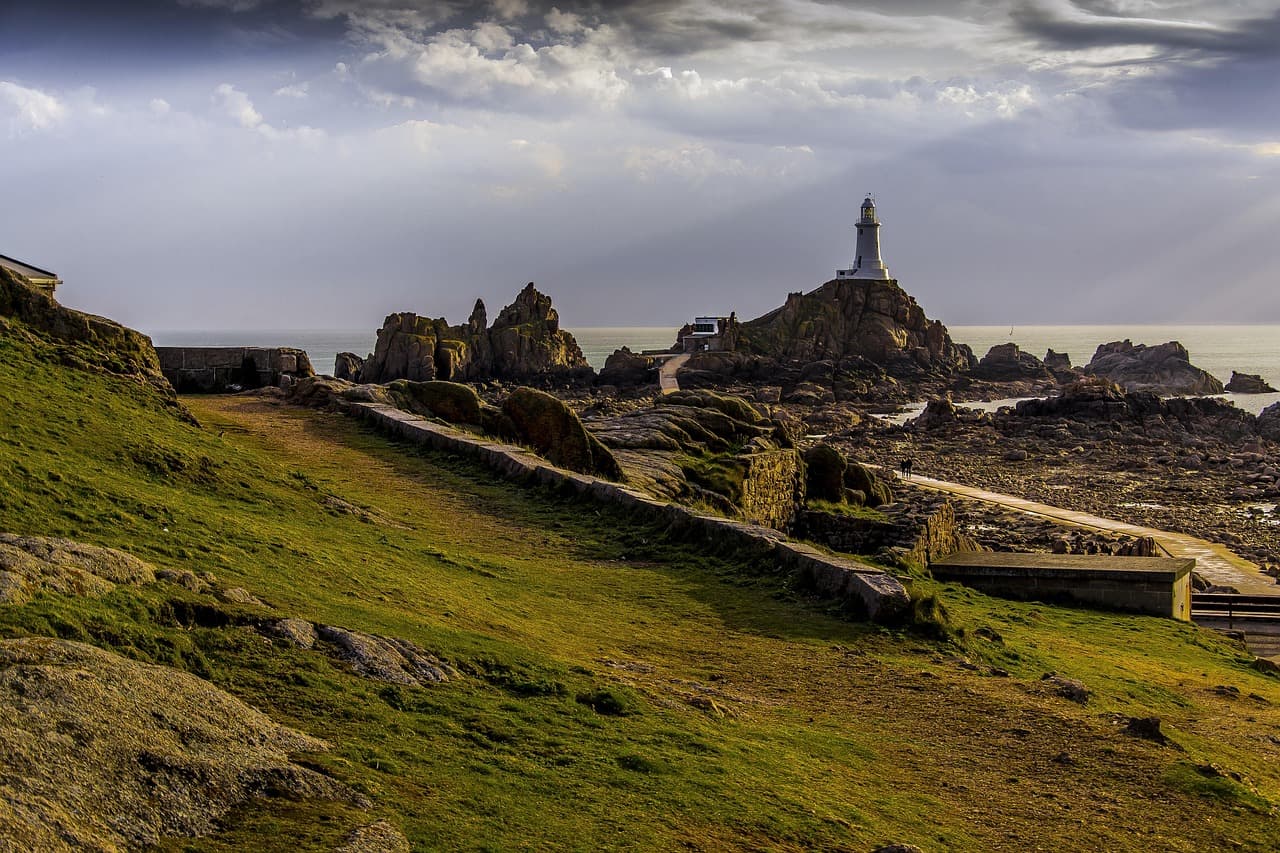 La côte verdoyante de Jersey avec le phare de La Corbière en toile de fond.