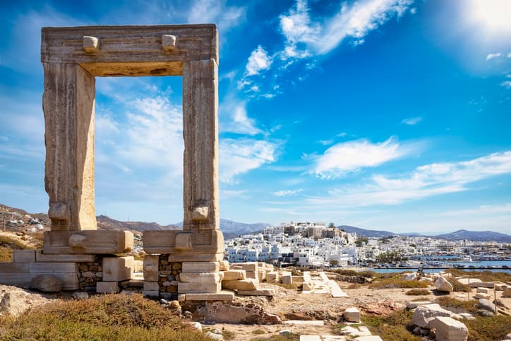 La célèbre porte de l'île de Naxos, appelée Portara, provenant du temple d'Apollon, devant les maisons blanchies à la chaux de la ville, sans personne, Cyclades, Grèce.