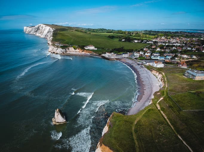 Une baie aux falaises blanches et aux dunes vertes.