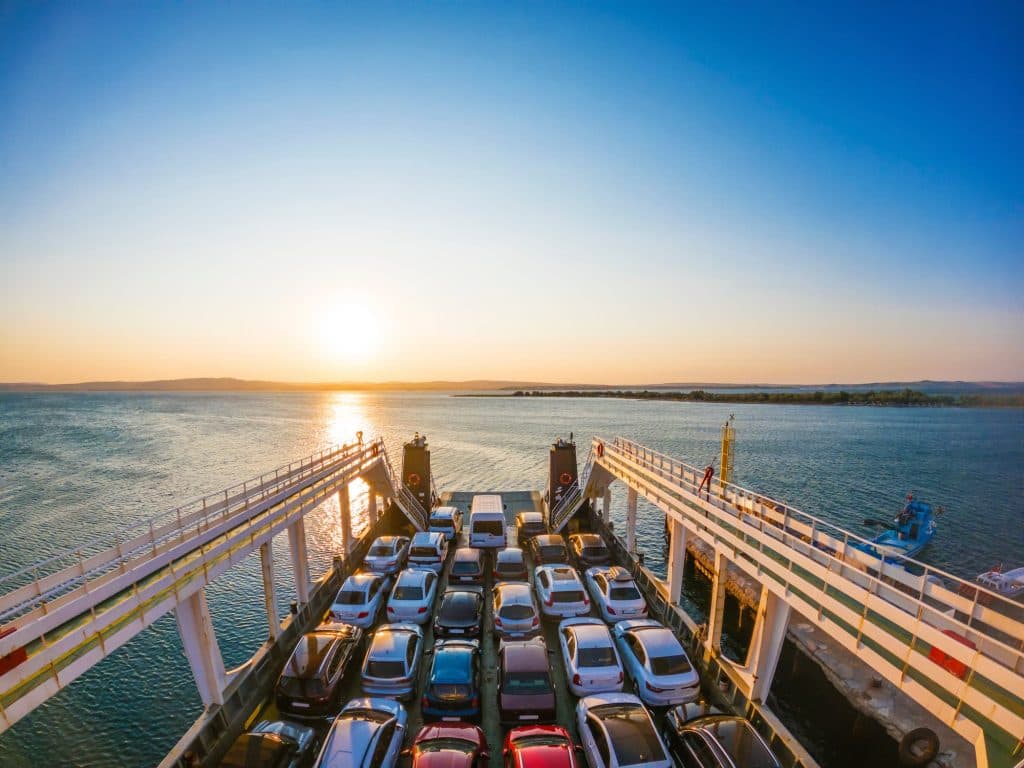 Traghetto al tramonto con auto imbarcate