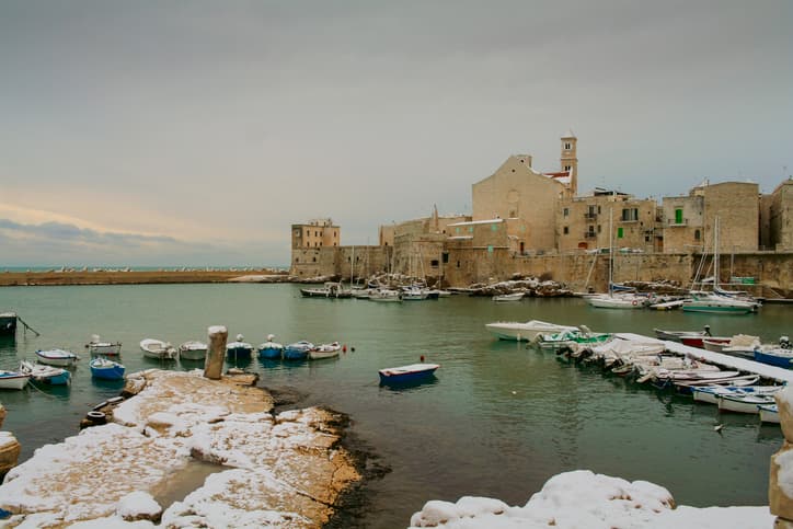 View of snow covered old town: on background the Cathedral of Santa Maria Assunta in Apulian Romanesque style.