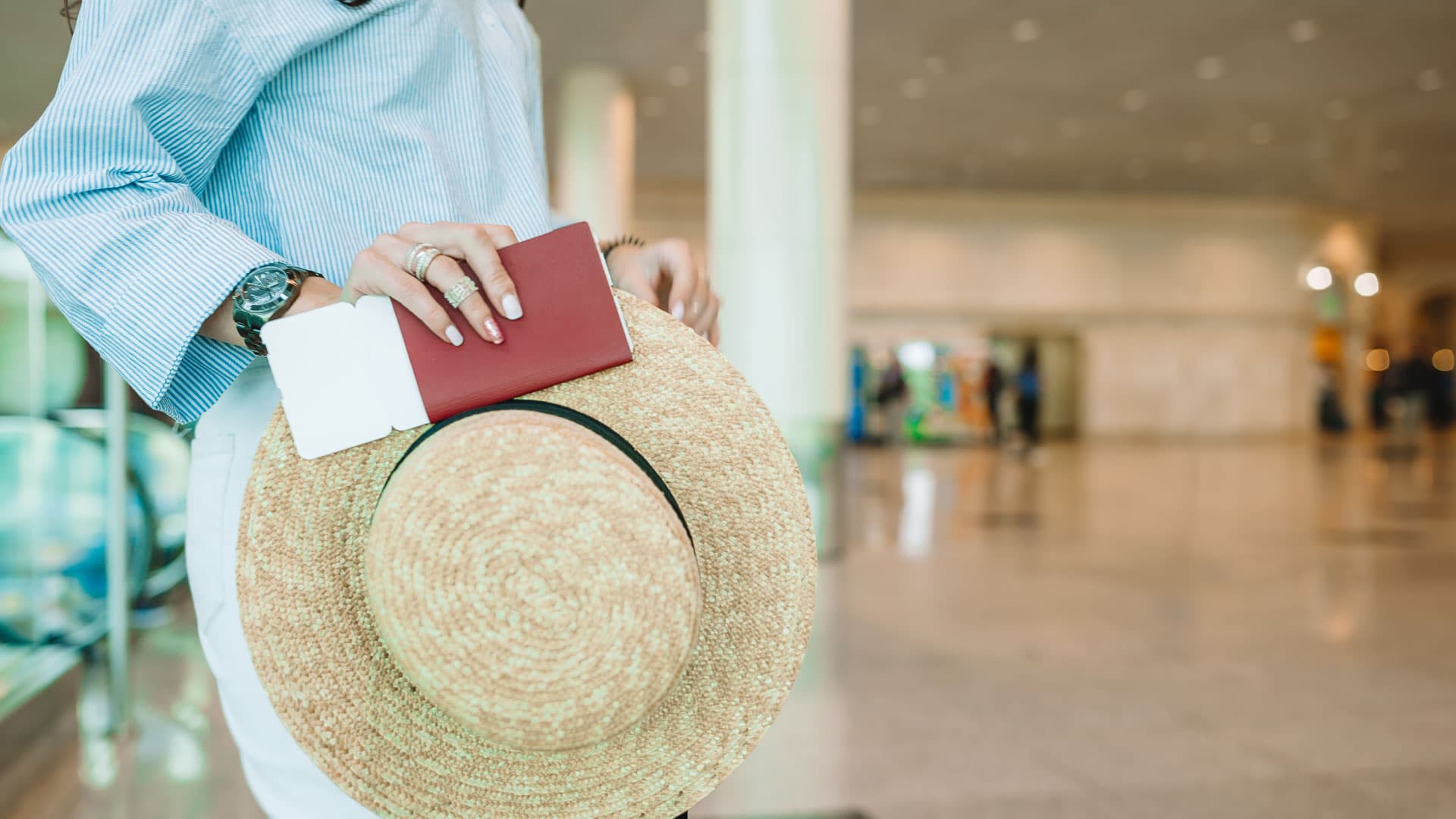 Bir kadın otobüs terminalinde pasaportunu tutuyor.