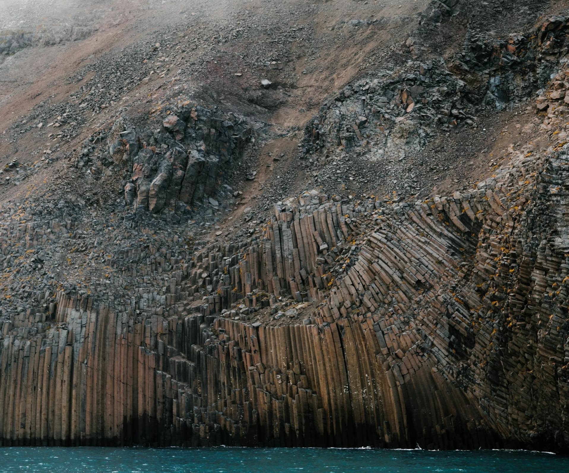 Strange rock formation, like small pillars piled up at the water's edge