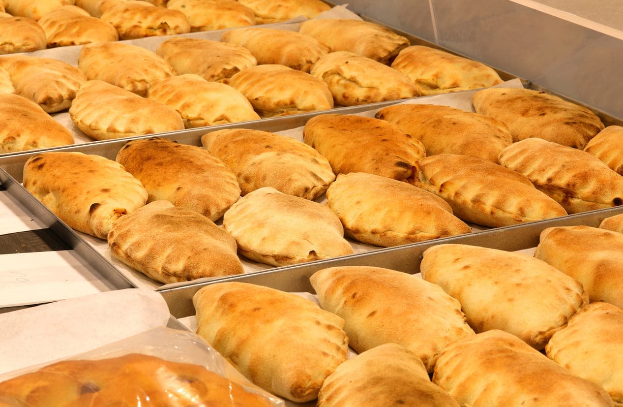 Panzerotti, tasche di pasta fritta ripiene di salsa di pomodoro e mozzarella fusa, tradizionalmente preparate a Bari, Italia.