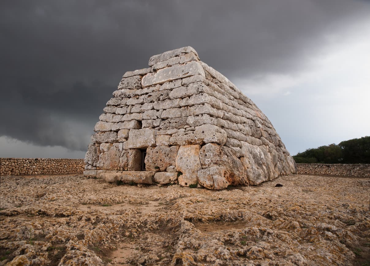 Une étrange construction mégalithique sous un ciel gris foncé.
