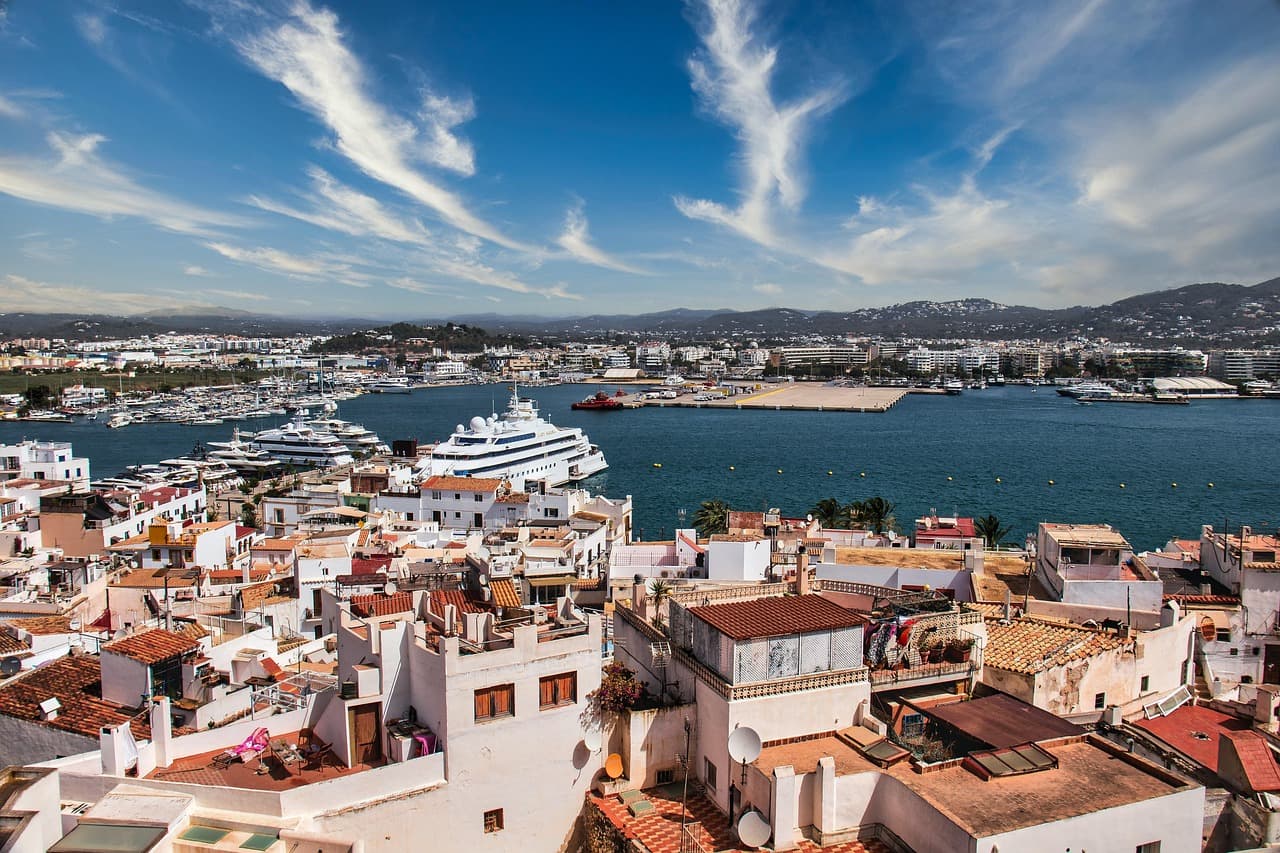 Port of Ibiza with beautiful buildings and a huge yacht by the bay