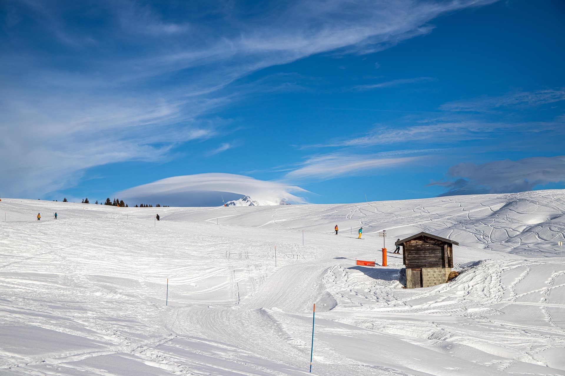 Un paysage de montagne enneigé avec un petit refuge.