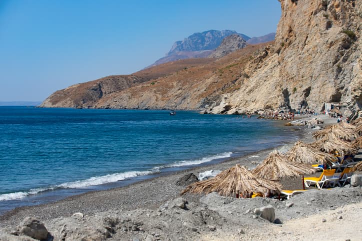 Embros Therma, a beach with a hot thermal spring, cliffs and umbrellas on a sunny day on the Greek island of Kos