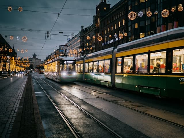 Tram illuminato che attraversa il centro decorato per Natale a Helsinki, tra luci festive e palazzi storici.