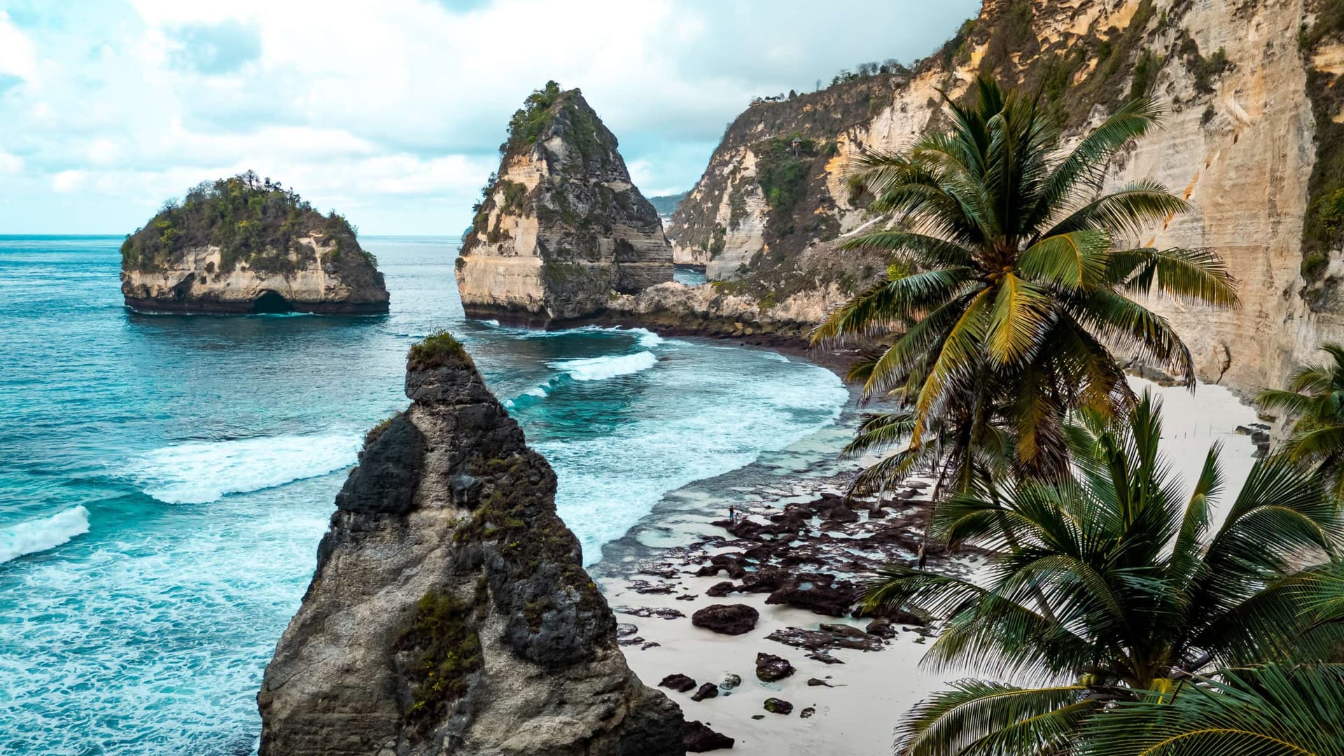 A daytime photo of Diamond Beach in Nusa Penida. The view of the rocks stretching along the beach 