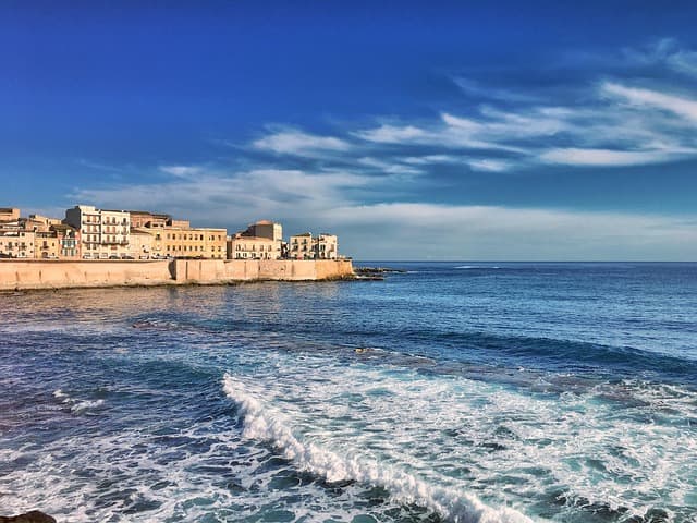 Vista sul lungomare di Ortigia a Siracusa con il mare e le case storiche affacciate sulla costa