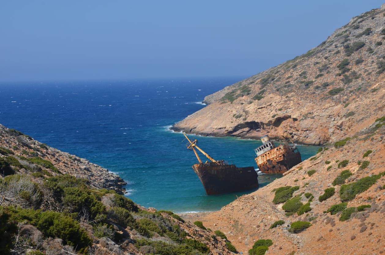L'épave d'un bateau du XXe siècle sur une petite crique sous un soleil de plomb