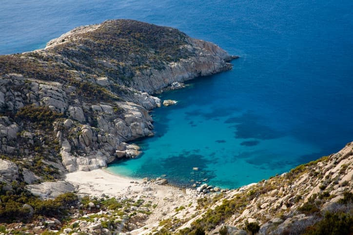 Cala rocciosa sull’isola di Montecristo con acqua turchese e costa selvaggia