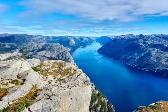 Panorama del Lysefjord in Norvegia visto dal Preikestolen, con scogliere rocciose e fiordo circondato dalle montagne.