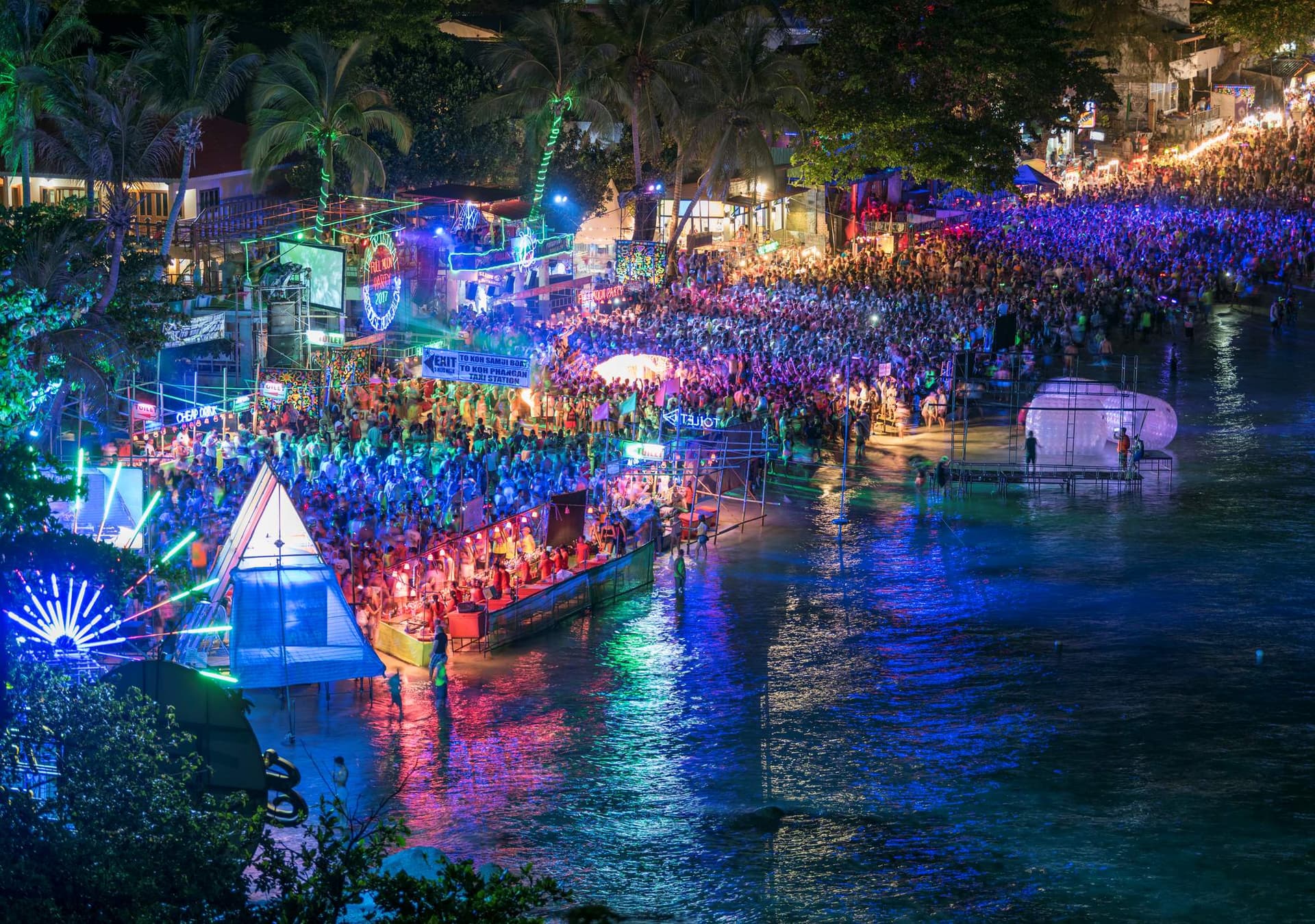 Green, red and blue lights glow across a party scene on NYE in Koh Phangan, Thailand.
