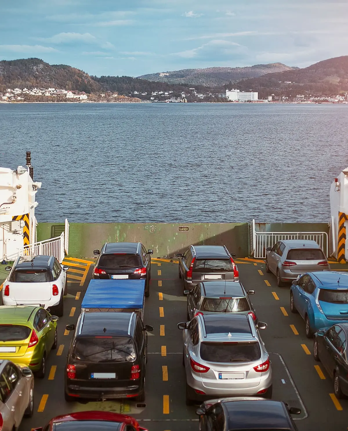 View of multiple cars parked on a ferry deck during a sea crossing.