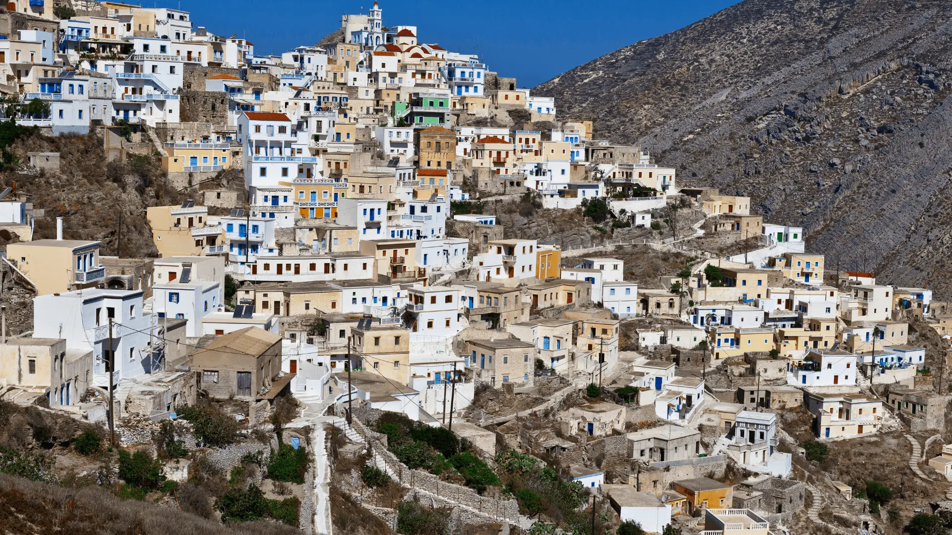 Veduta panoramica di Olympos a Karpathos, una delle isole vicino a Creta, con case bianche e scogliere sul Mar Egeo.