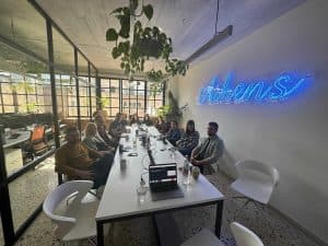 group of people sitting around a white conference table desk after participating in a management training