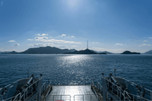 view from the back of the ship crossing the waves with the hot sun in the sky