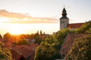 solen skiner genom byggnaderna i visby, sverige