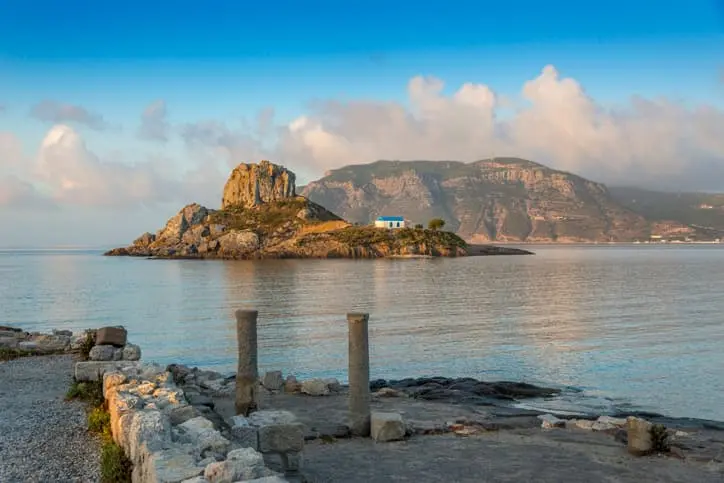 Isolotto di Kastri con la chiesetta bianca a Kos, visto tra colonne antiche