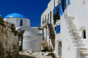 white buildings with blue details and a white church with a blue dome