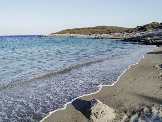 Spiaggia sabbiosa con mare turchese e onde leggere sull’isola di Antiparos.