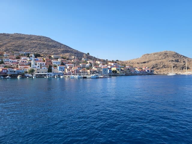 Porticciolo di Chalki con case colorate affacciate sul mare, una delle isole greche senza auto