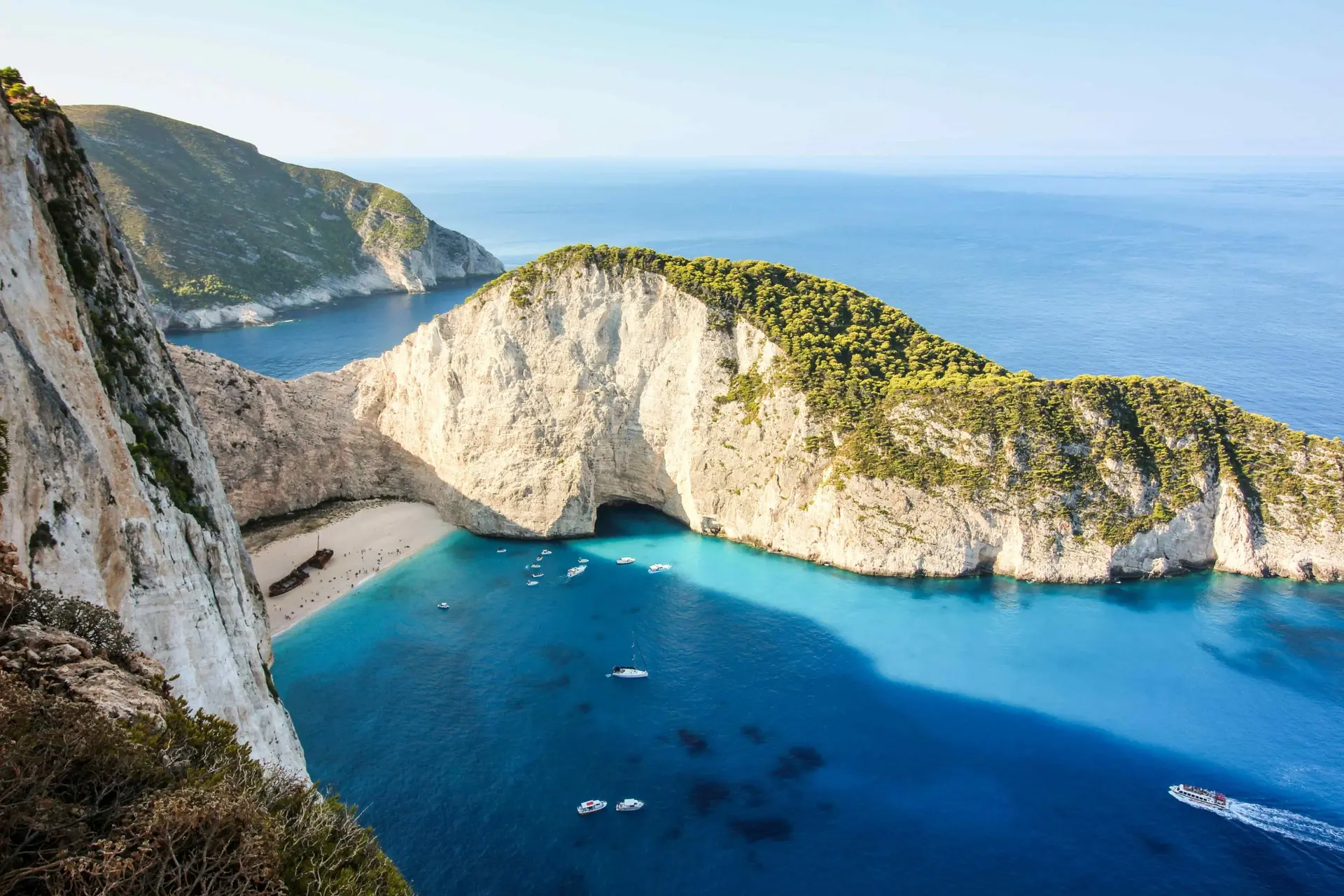 Ναυάγιο Ζακύνθου – Η εμβληματική παραλία με τα λευκά βράχια, τα τιρκουάζ νερά και το διάσημο κουφάρι πλοίου, προσβάσιμη μόνο με σκάφος, αποτελεί μία από τις πιο πολυφωτογραφημένες τοποθεσίες της Ελλάδας.