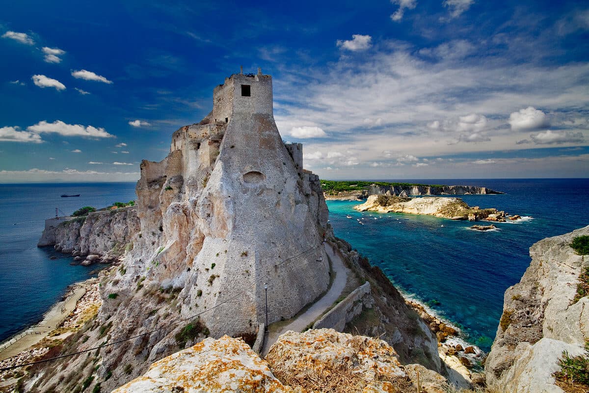 Ancient and ruined stone tower on a rocky promontory overlooking the sea