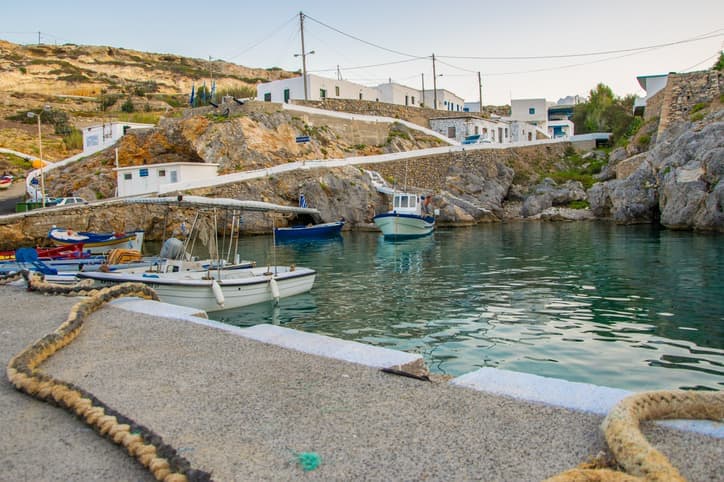 Piccolo porto con barche da pesca colorate e acque turchesi nel villaggio di Potamos nell'isola di Antikythera in Grecia